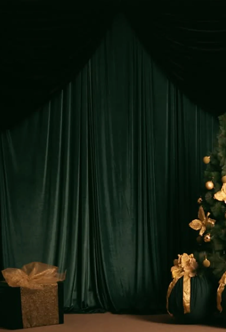Visão mais ampla da decoração de Natal com cortinas verdes, presente e árvore iluminada